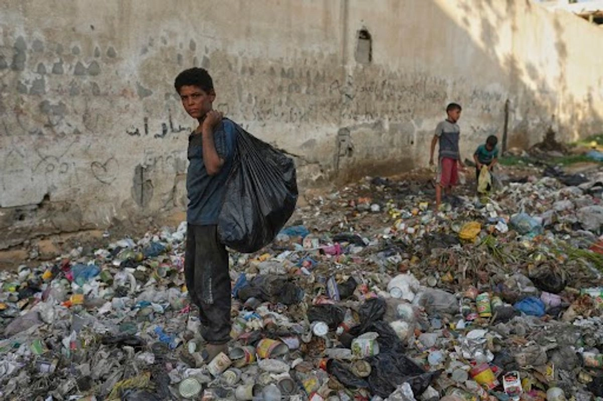 Yassin al Masry, de 13 años, recolecta plástico entre la basura para hacer fuego con el cual cocinar, en la ciudad de Gaza. Foto 