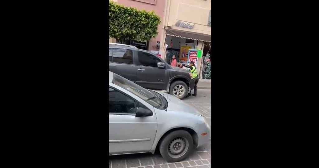 Familiares del presunto infractor golpearon al oficial tras haber intentado levantar una infracción por estacionarse en un lugar prohibido. Captura de pantalla de un video de X.