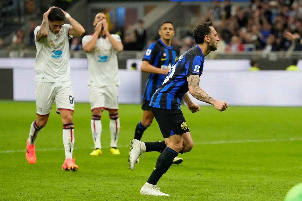 Hakan Calhanoglu, del Inter de Milán, a la derecha, celebra después de anotar el segundo gol de su equipo durante el partido de fútbol de la Serie A italiana entre el Inter de Milán y Cagliari en el estadio de San Siro en Milán, Italia, el 14 de abril de 2024. Foto Ap