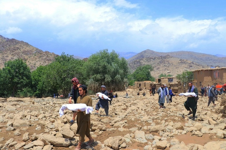 Los residentes afganos llevan los cuerpos de los niños, que murieron en inundaciones repentinas en el distrito de Jalrez de la provincia de Maidan Wardak el 23 de julio de 2023. Foto Afp
