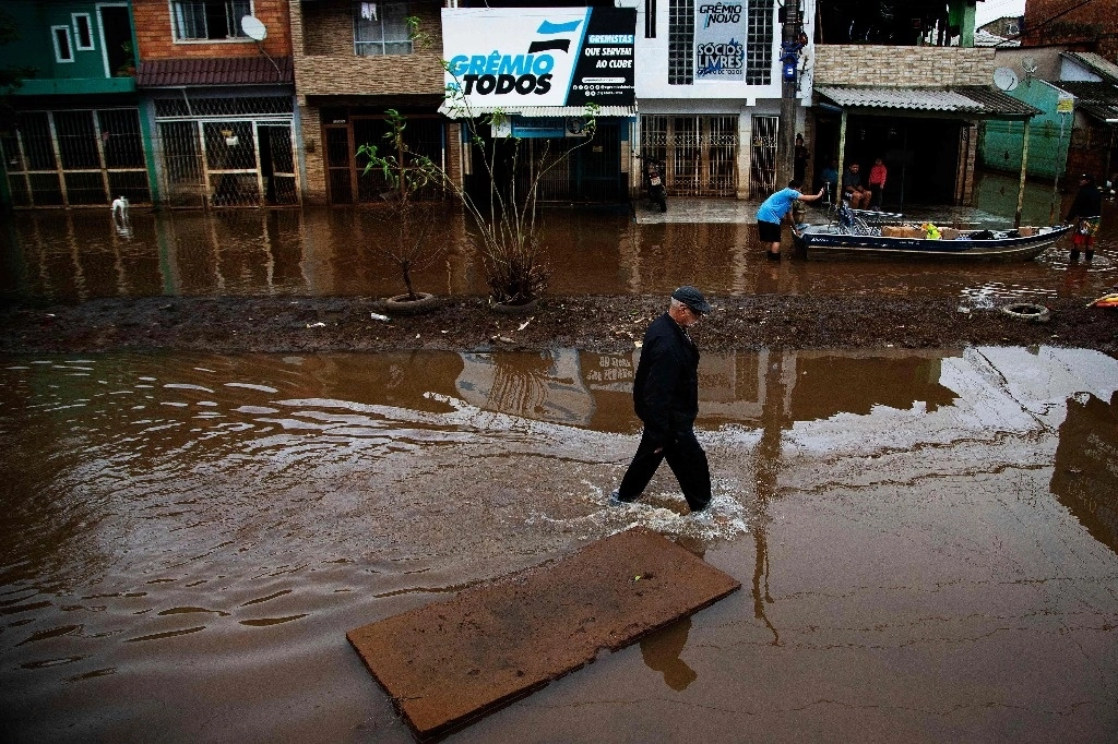 La gente camina por una calle inundada alrededor del estadio Arena do Gremio en Porto Alegre, estado de Rio Grande do Sul, Brasil, el 29 de mayo de 2024. Foto Afp