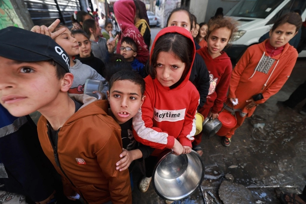 Niños palestinos esperan por comida en Rafah. Foto Afp 



