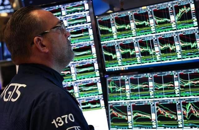 Trabajador de la Bolsa de Nueva York observa diversas acciones. Foto 