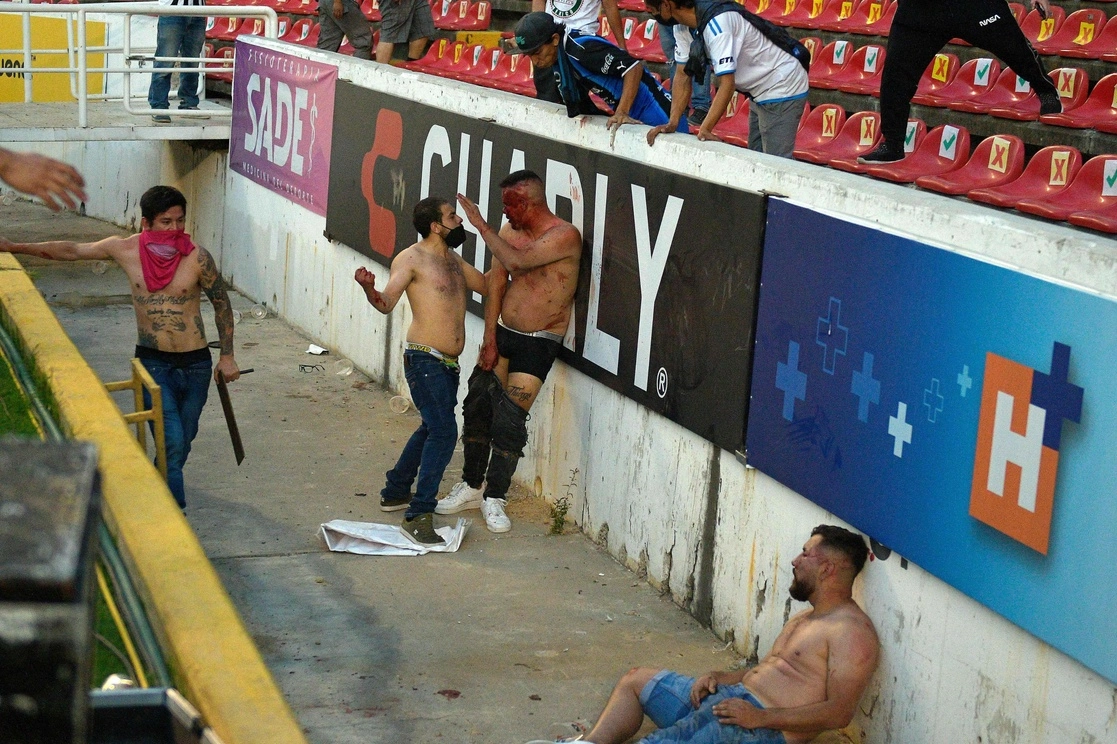 Golpizas salvajes de varios sujetos contra uno solo, agresiones en las que se usaban proyectiles de todo tipo y familias aterrorizadas, fueron algunas escenas que se vivieron ayer en el estadio Corregidora de Querétaro. Foto Cuartoscuro y Afp