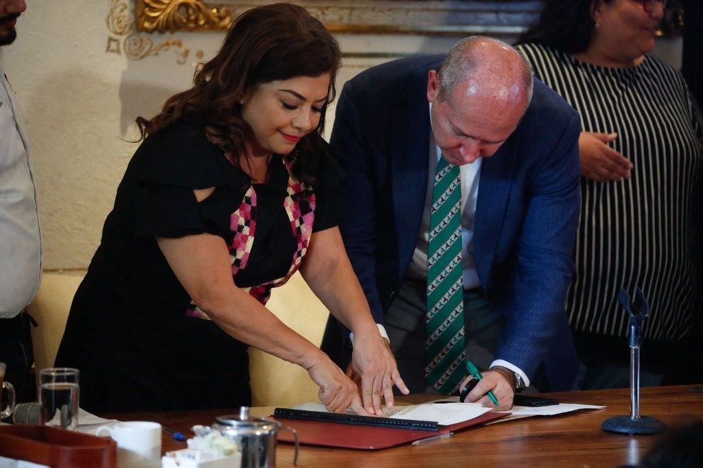 La candidata a la jefatura de gobierno por la coalición Sigamos Haciendo Historia en la CDMX, Clara Brugada, firma ante el notario Fernando Pérez Arredondo una denuncia por difamación, en una conferencia de prensa realizada en un restaurante al sur de la Ciudad de México, el 28 de mayo de 2024. Foto Cristina Rodríguez