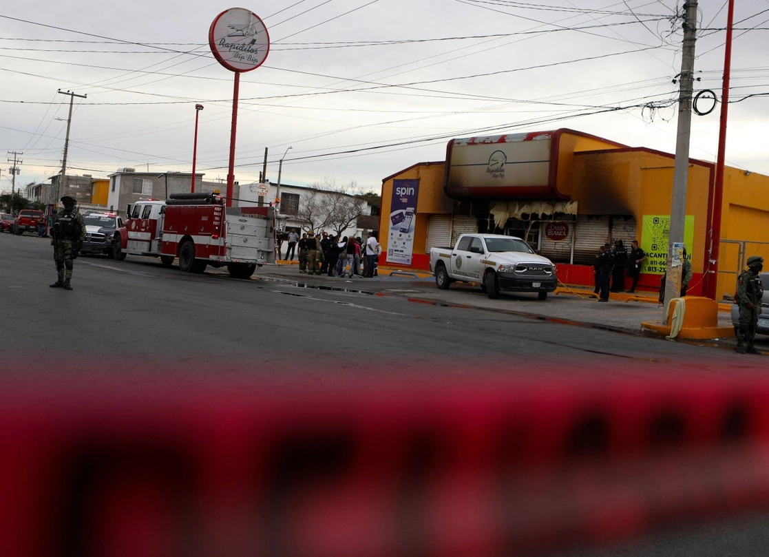Militares y peritos resguardan hoy la zona donde sujetos armados incendiaron anoche comercios en Ciudad Juárez, Chihuahua. Foto Afp