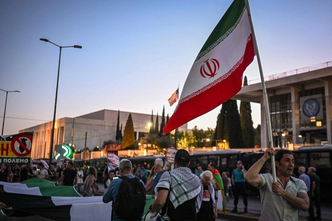 Una bandera iraní es ondeada en Atenas, Grecia, donde se manifestaron en contra del ataque de EU a instalaciones nucleares de Irán. Foto 