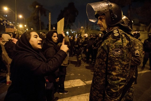 Mujer encara a policía en la Universidad de Irán durante la vigilia por las víctimas del avión derribado por ejército iraní. Foto Ap