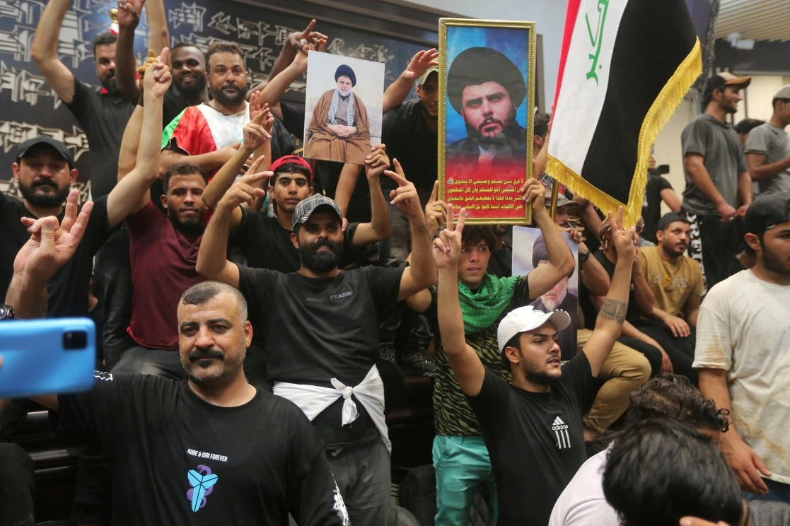 Manifestantes iraquíes posan con banderas nacionales e imágenes del clérigo chiíta Muqtada al-Sadr dentro del edificio del Parlamento en Bagdad, Irak, el sábado 30 de julio de 2022. Foto Ap