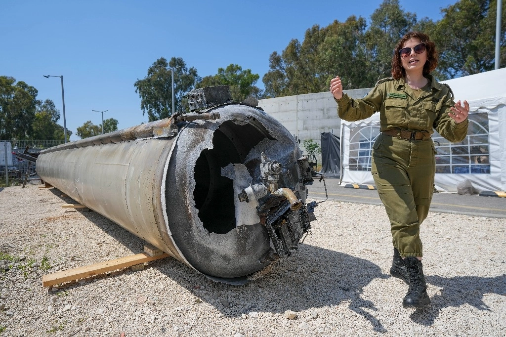 La subdirectora militar del departamento de prensa internacional de las Fuerzas de Defensa de Israel, Masha Michelson, muestra a los medios uno de los misiles balísticos iraníes que Israel interceptó durante el fin de semana, en la base militar Julis, en el sur israelí. Foto Ap



