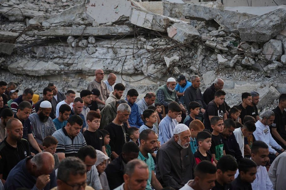 Palestinos rezan junto a las ruinas de una mezquita destruida hace pocos días por proyectiles del ejército israelí, en Deir al Balah. Foto