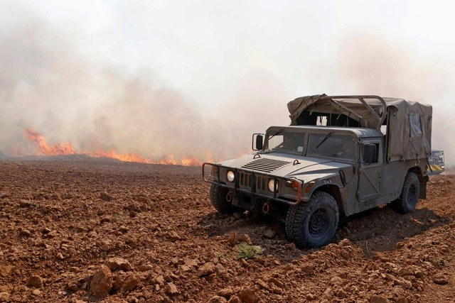 Militares de Israel observan los incendios ocasionados por globos incendiarios lanzados desde la Franja de Gaza. Foto Afp