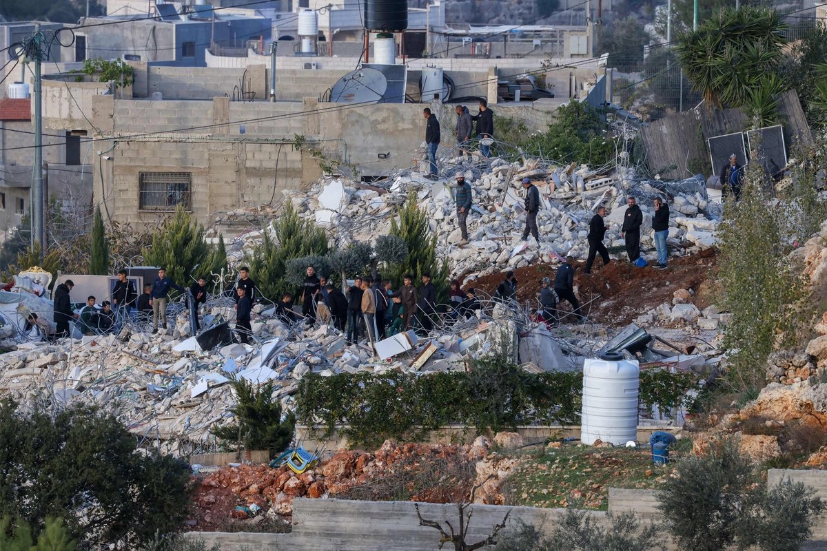 Personas inspeccionan los escombros de dos casas palestinas demolidas por las fuerzas de seguridad israelíes por supuestamente haber sido construidas sin permiso en la aldea de Husan, cerca de Belén, en Cisjordania ocupada, el 9 de diciembre de 2025. Foto 