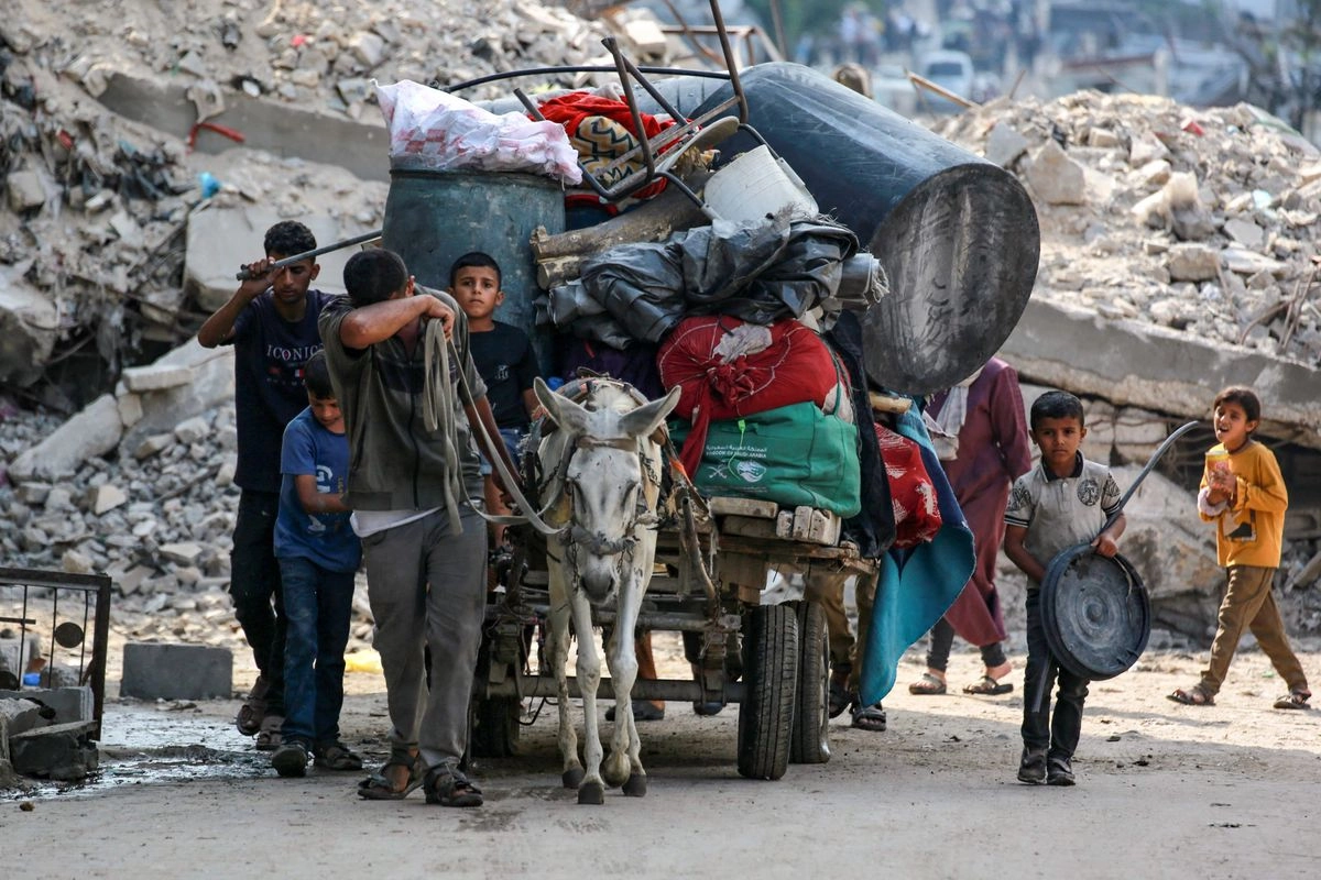 Palestinos transportan sus pertenencias en un carro tirado por burro mientras huyen del barrio de Abu Iskandar en el norte de la ciudad de Gaza, el 22 de agosto de 2025. 