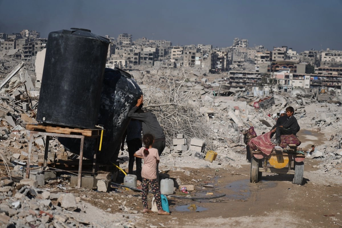 Palestinos recogen agua entre las ruinas de la ciudad de Gaza, el 26 de octubre de 2025.