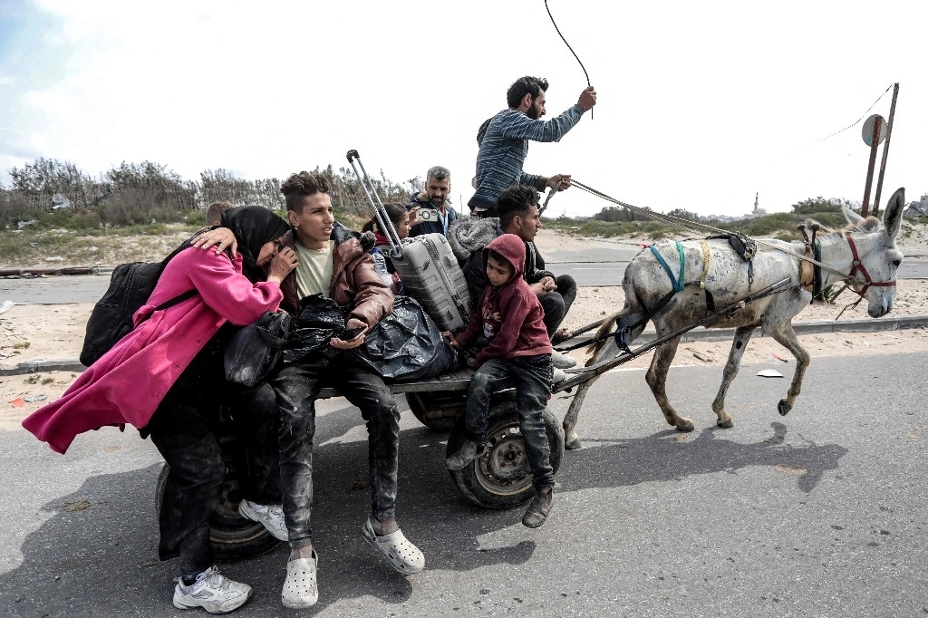 Palestinos desplazados escapan del hospital Al Shifa de Gaza, hacia un campo de refugiados este lunes. Foto Afp 