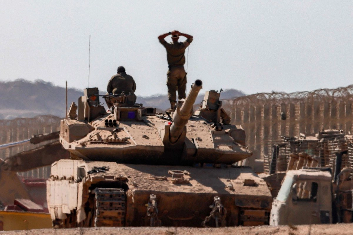 Un soldado del ejército israelí se encuentra en la torreta de un tanque de batalla principal Merkava junto a otro soldado, apostados cerca de excavadoras militares blindadas a lo largo de la frontera con la Franja de Gaza, en el sur de Israel, el 2 de septiembre de 2025.

