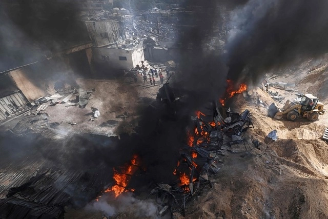 Bomberos palestinos controlan un gran incendio en una fábrica de colchones al norte de la franja de Gaza. Foto Afp 