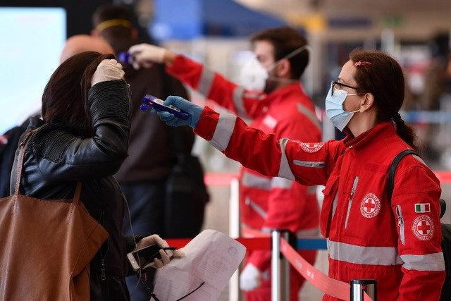 Trabajadores de la Cruz Roja toman la temperatura a pasajeros en la estación de trenes Termini en Roma, Italia. Foto Xinhua
