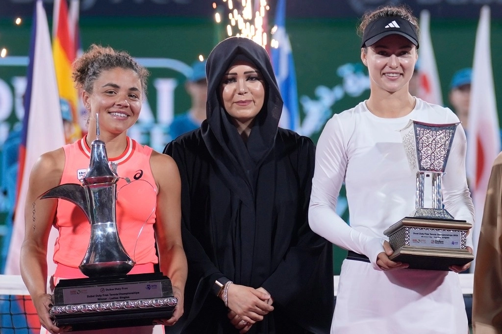 La ganadora, Jasmine Paolini de Italia, izquierda, y Anna Kalinskaya, derecha, posan para una fotografía con Sheikha Latifa bint Mohammed bin Rashid al Maktoum al final de su último partido del WTA 1000 de Duabái. Foto Ap