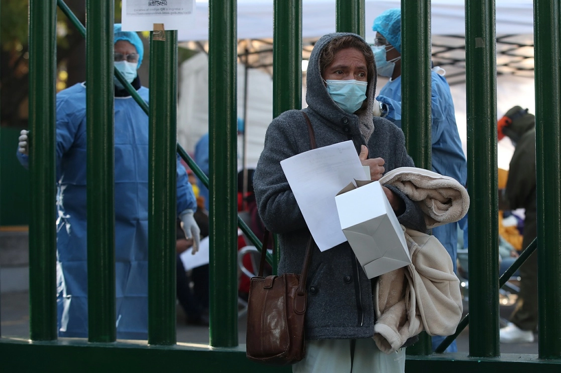 Una mujer que dio positivo a covid-19 se aleja del Hospital General Regional 1 "Dr. Carlos Mac Gregor Sánchez Navarro" del IMSS con un kit de medicamentos, en la Ciudad de México, el 15 de enero de 2022. Foto José Antonio López 
