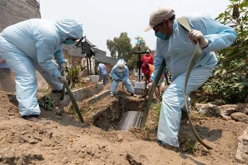 Trabajadores del panteón civil de San Nicolás Tolentino, en Iztapalapa, durante el servicio de inhumación de un cuerpo con Covid-19. Foto Pablo Ramos