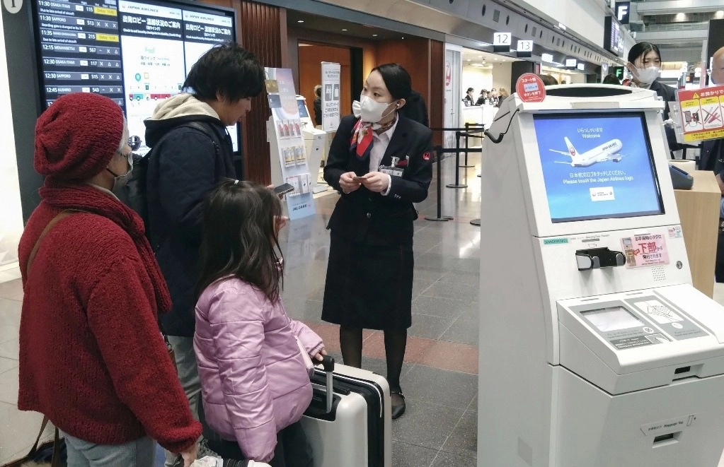 Un miembro del personal de Japan Airlines ayuda a los clientes en el aeropuerto de Haneda en Tokio, el jueves 26 de diciembre de 2024, después de que la aerolínea dijera que había sido víctima de un ciberataque. Foto Ap