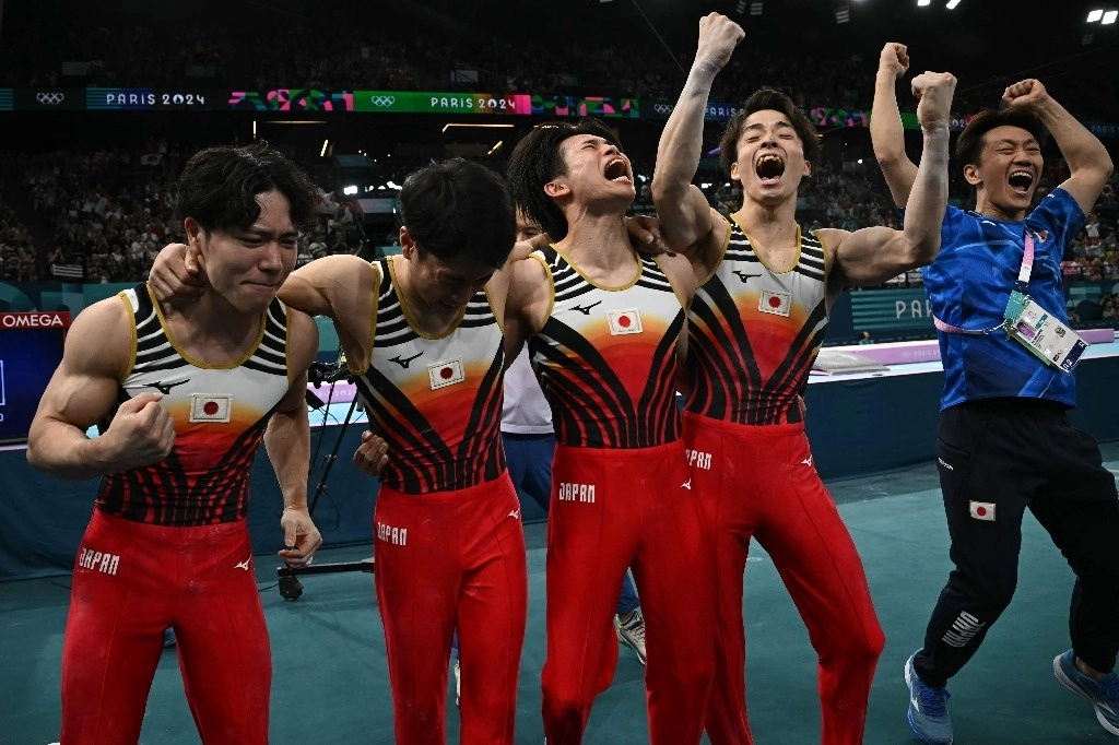 El equipo japonés celebra con emoción su victoria ante China y Estados Unidos en la competición de gimnasia artística. Foto Afp  