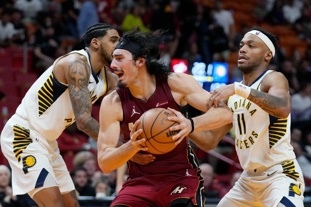 El delantero del Miami Heat, Jaime Jaquez Jr., centro, toma un rebote contra el base de los Indiana Pacers, Bruce Brown (11) y el delantero Obi Toppin, izquierda, durante la segunda mitad del partido. Foto Ap