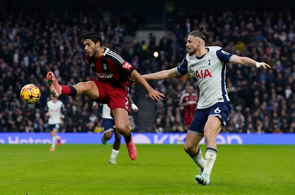 Raúl Jiménez, del Fulham, a la izquierda, y Radu Dragusin, del Tottenham Hotspur, en acción durante el partido de fútbol de la Liga Premier inglesa en el estadio Tottenham Hotspur, Londres, el domingo 1 de diciembre de 2024. Foto Ap