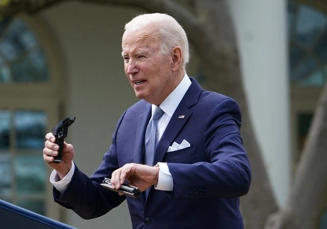 El presidente de Estados Unidos muestra una arma falsa, durante el anunció de nuevas medidas de control. Foto Afp