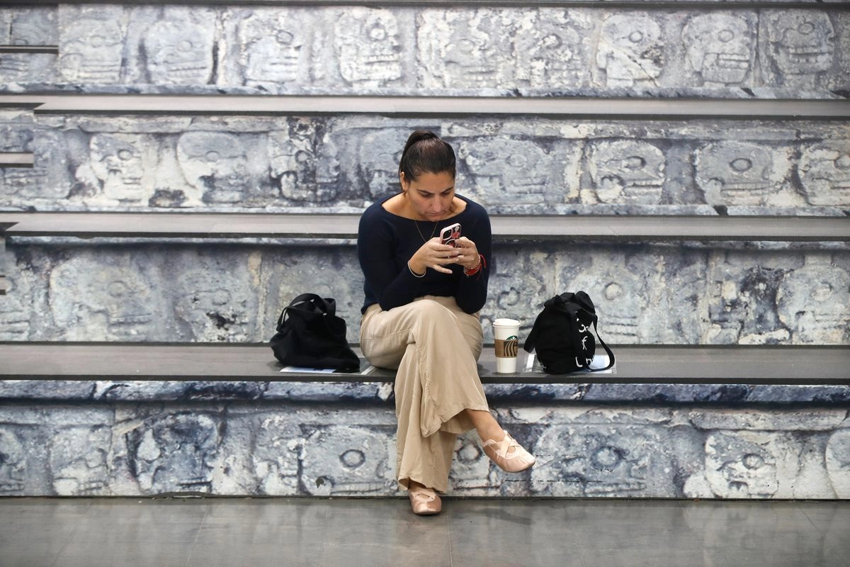 Una mujer observa su celular en el AICM, el 9 de febrero de 2025. Foto 