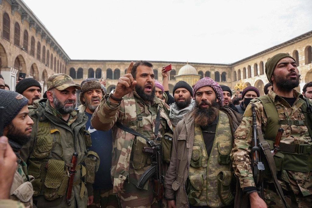 Combatientes celebran en la mezquita Omeyyad de Damasco, luego que los rebeldes se hicieran con el control de la capital, lo que obligó la huida del presidente Bashar al Assad. Foto Afp