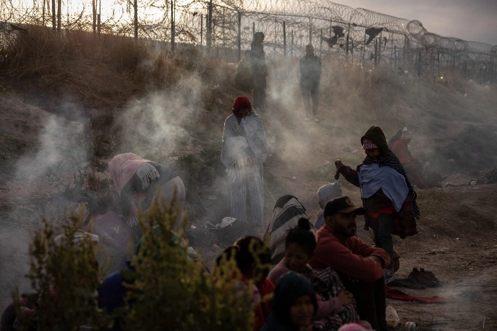 Migrantes venezolanos esperan frente a la valla fronteriza que separa Ciudad Juárez, Chihuahua de El Paso. Texas. Foto Afp