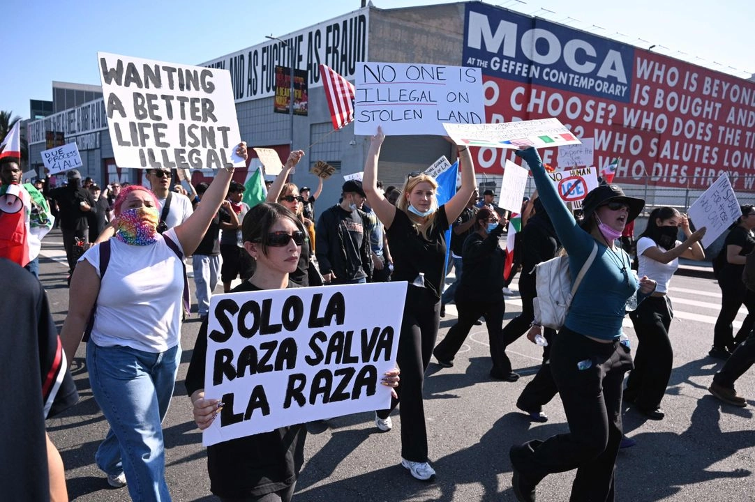 Personas con pancartas marchan frente al Geffen Contemporary del MOCA durante las protestas en curso en respuesta a los operativos federales de inmigración en el centro de Los Ángeles, el 12 de junio de 2025.  Foto