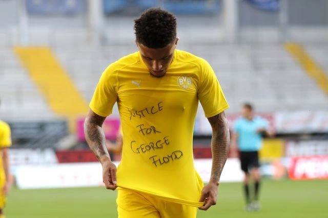 El jugador del Dortmund, Jadon Sancho, protesta por la muerte de George Floyd durante el partido contra el Paderborn. Foto Afp