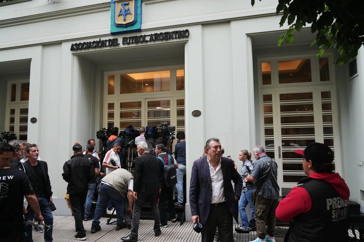 Periodistas frente a la sede de la Asociación del Futbol Argentino (AFA), que fue allanada en la causa por presunto lavado de dinero de una financiera vinculada a la federación local, el 9 de diciembre de 2025. Foto 