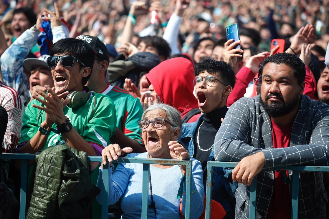 Aficionados asisten a la proyección del cotejo entre México y Polonia, en el marco del FIFA Fan Fest ubicado en la explanada del Monumento a la Revolución, en la Ciudad de México. Foto Cristina Rodríguez.