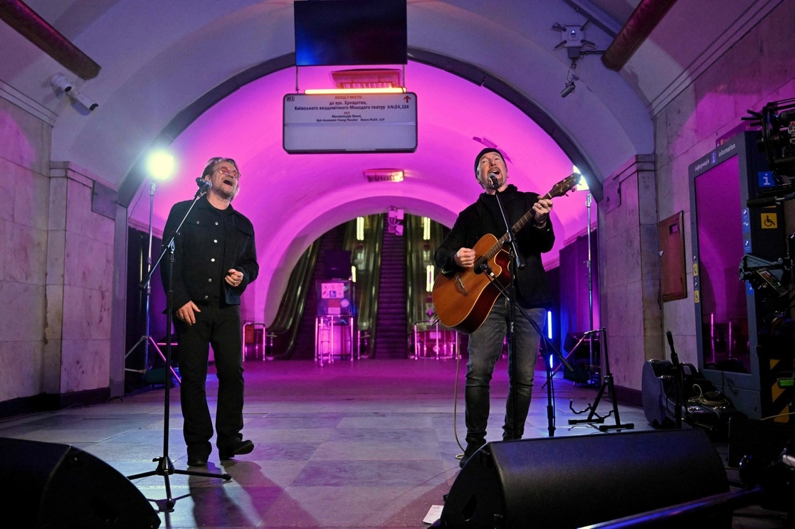 El cantautor irlandés 'Bono' activista y vocalista de la banda de rock 'U2', y el guitarrista David Howell Evans  también conocido como 'The Edge', durante un concierto en una estación de metro que es un refugio antiaéreo, en el centro de la capital ucrania de Kiev, el 8 de mayo de 2022. Foto Afp