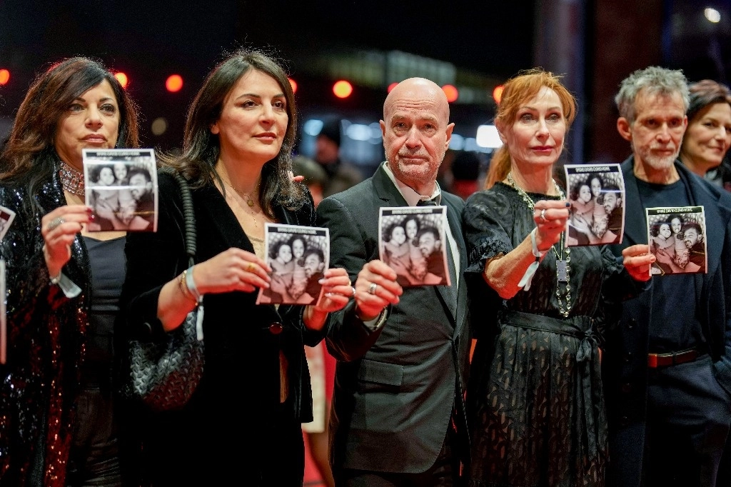 Actores alemanes sostienen fotografías del artista israelí David Cuni, secuestrado por Hamas, a su llegada a la inauguración del Festival Internacional de Cine de Berlín. Foto Afp