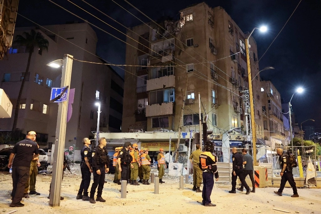 Las fuerzas de seguridad israelíes y rescatistas se reúnen frente a un edificio en Tel Aviv, después de que fuera alcanzado por un cohete disparado por militantes palestinos desde la Franja de Gaza el 7 de octubre de 2023. Foto Afp