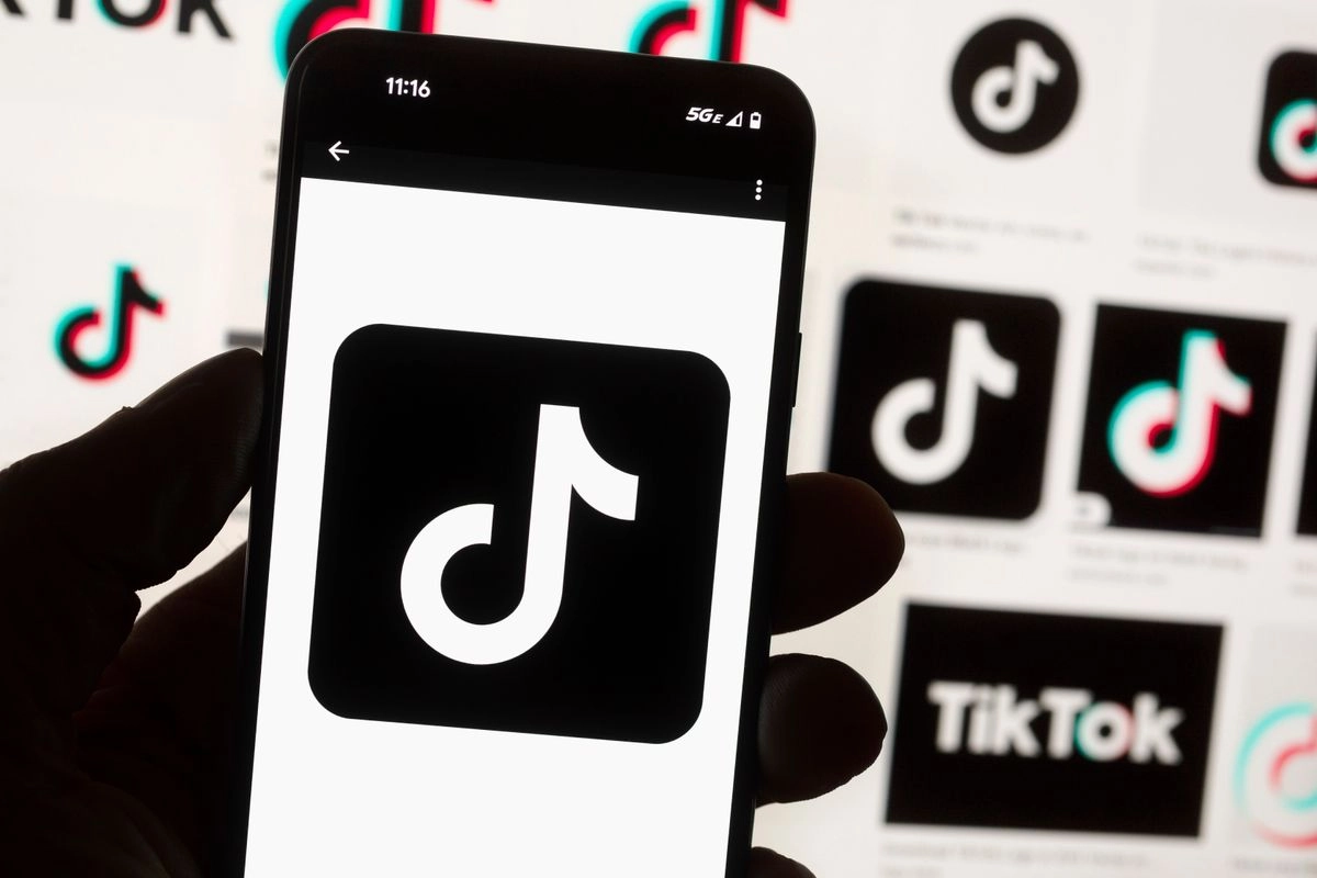 El logo de TikTok se ve en un teléfono móvil frente a la pantalla de una computadora que muestra la pantalla de inicio de TikTok, el 14 de octubre de 2022, en Boston. Foto