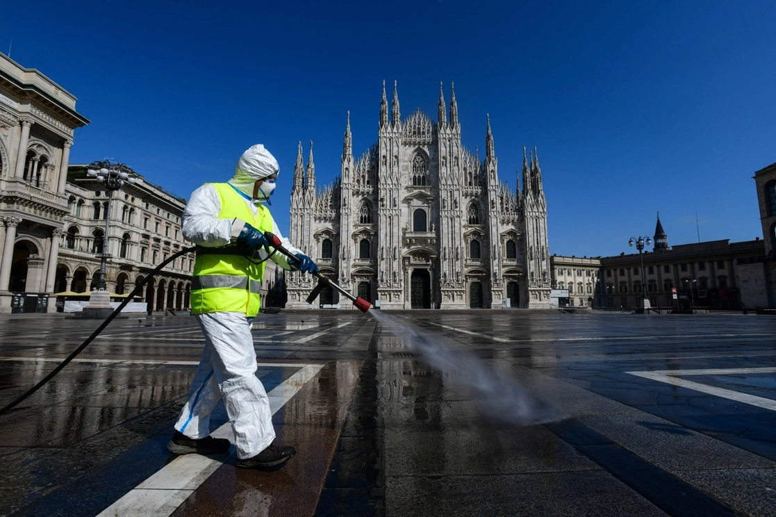 Un trabajador rocía desinfectante en la Piazza del Duomo, en Milán, a comienzos del confinamiento el 31 de marzo de 2020. Foto Afp
