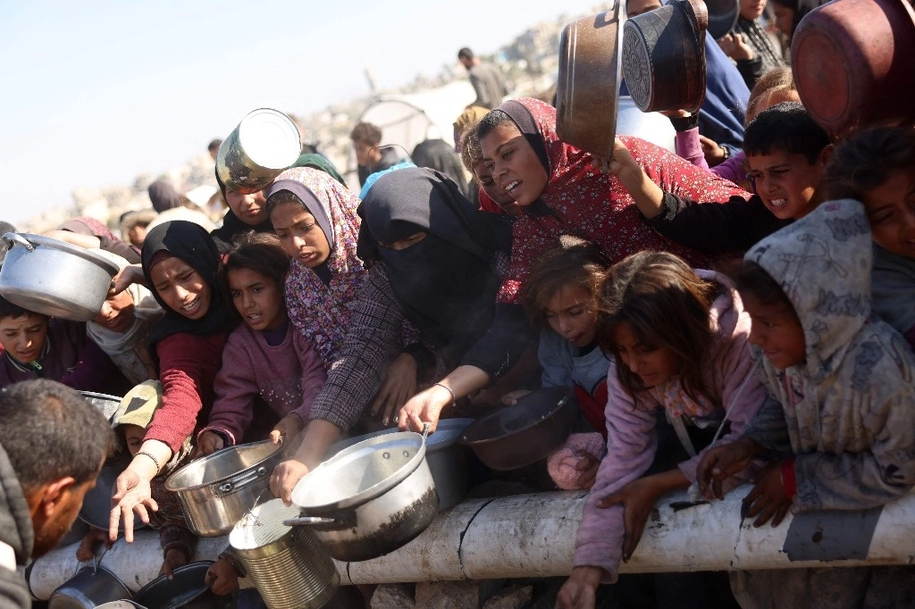 Los palestinos esperan una porción de comida en un centro de distribución al sur de Khan Yunis, en el sur de la Franja de Gaza, el 17 de diciembre de 2024, en medio de la guerra en curso entre Israel y el movimiento palestino Hamas. Foto Afp