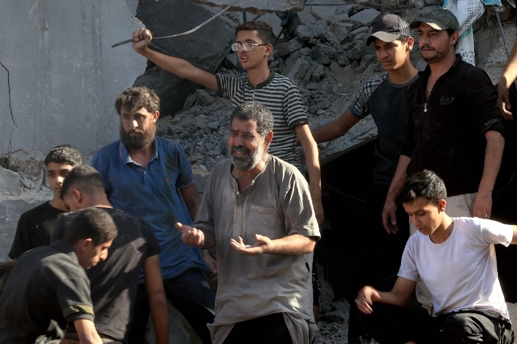 Palestinos reaccionan al observar una casa que fue alcanzada durante un ataque aéreo israelí en Rafá, en el sur de la franja de Gaza, ayer. Foto Afp 