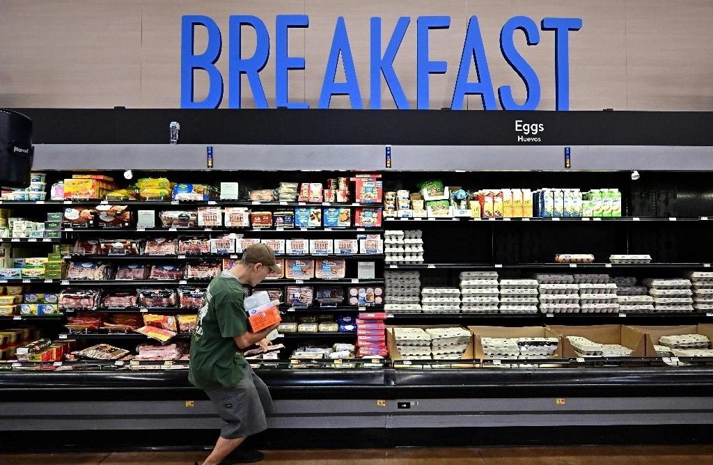 Un comprador recoge su paquete de tocino mientras compra alimentos en una tienda de comestibles en Rosemead, California. Foto Afp
