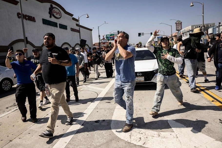 Migrantes celebran luego de expulsar a agentes que intentaban efectuar una redada en el sur de Los Ángeles. Foto 
