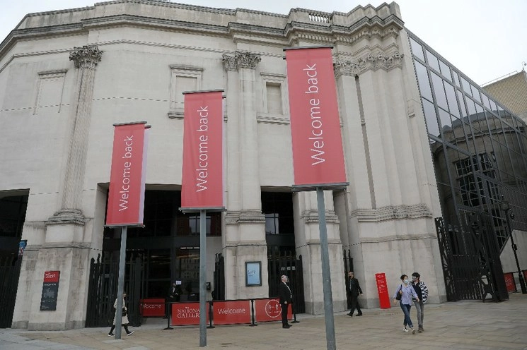 Personal con careta reciben a los visitantes de la Galería Nacional, en Londres. Foto AFP 