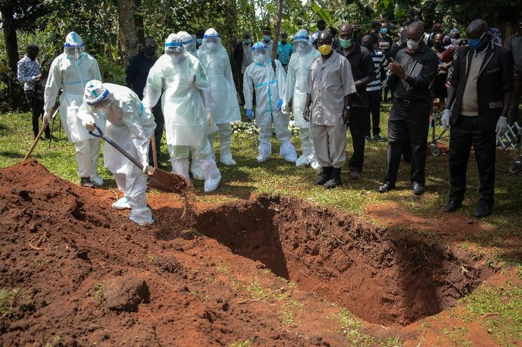Miembros del equipo de aislamiento del condado de Bungoma entierran el ataúd del doctor Doreen Lugaliki, de 39 años, el primer médico keniano fallecido de Covid-19 en Nairobi, Kenia. Foto Afp