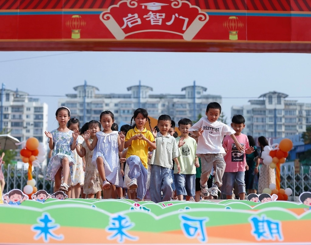 Un grupo de estudiantes atraviesa la Puerta de la Sabiduría en una escuela primaria en Qingdao, provincia de Shandong, en el este de China. Foto Xinhua